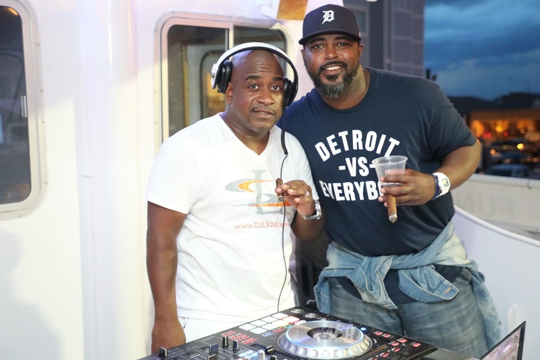 Chef Max Hardy standing with DJ LS One behind the decks on the Steven Thomas