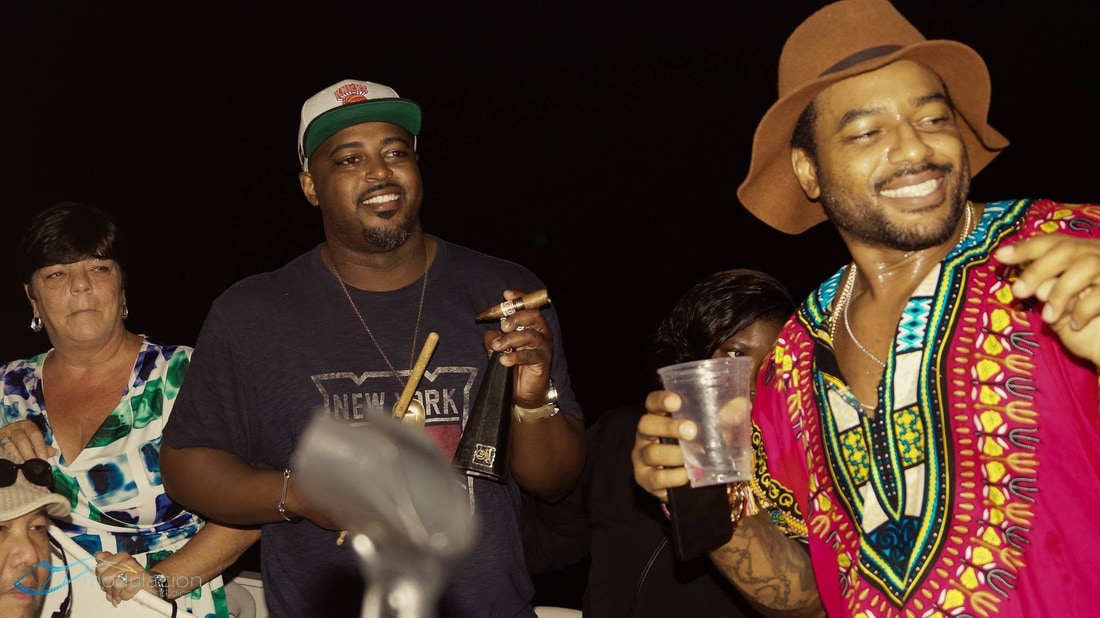 Chef Max Hardy with Larry Johnson and guests on the boat at night