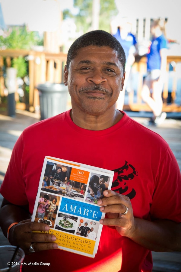 A guest at the crab party holding Chef Max Hardy's cookbook with Amar'e Stoudemire on the cover