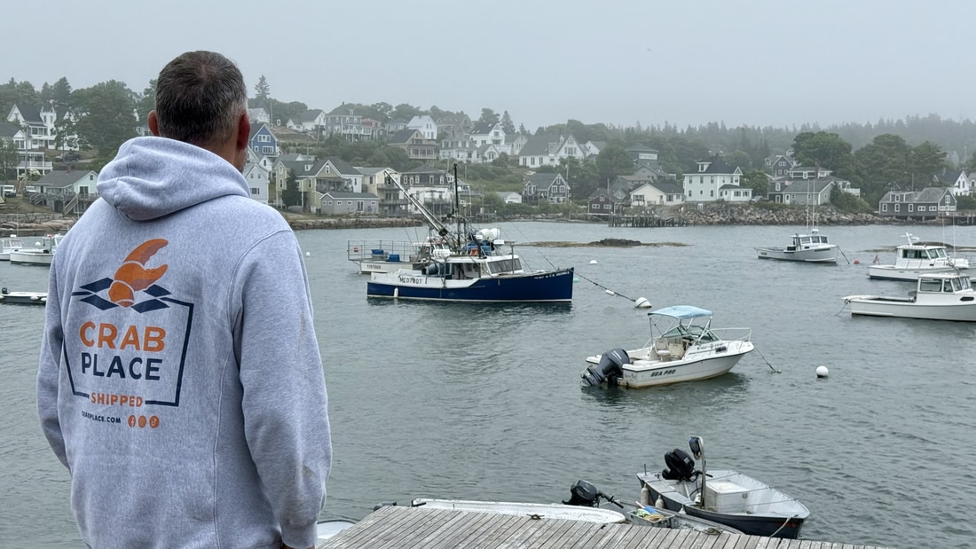 A Crab Place team member on the dock looking out over the village and harbor of Stonington, Maine