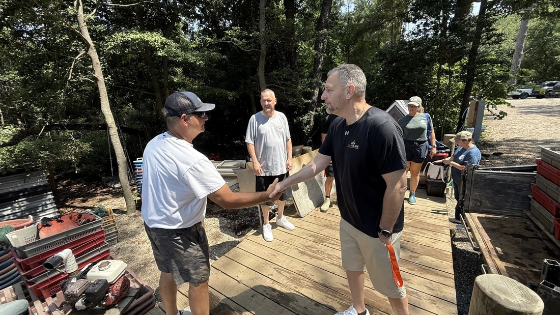 A Crab Place team member shaking hands with a waterman on the dock at the Cape Charles shellfish farm