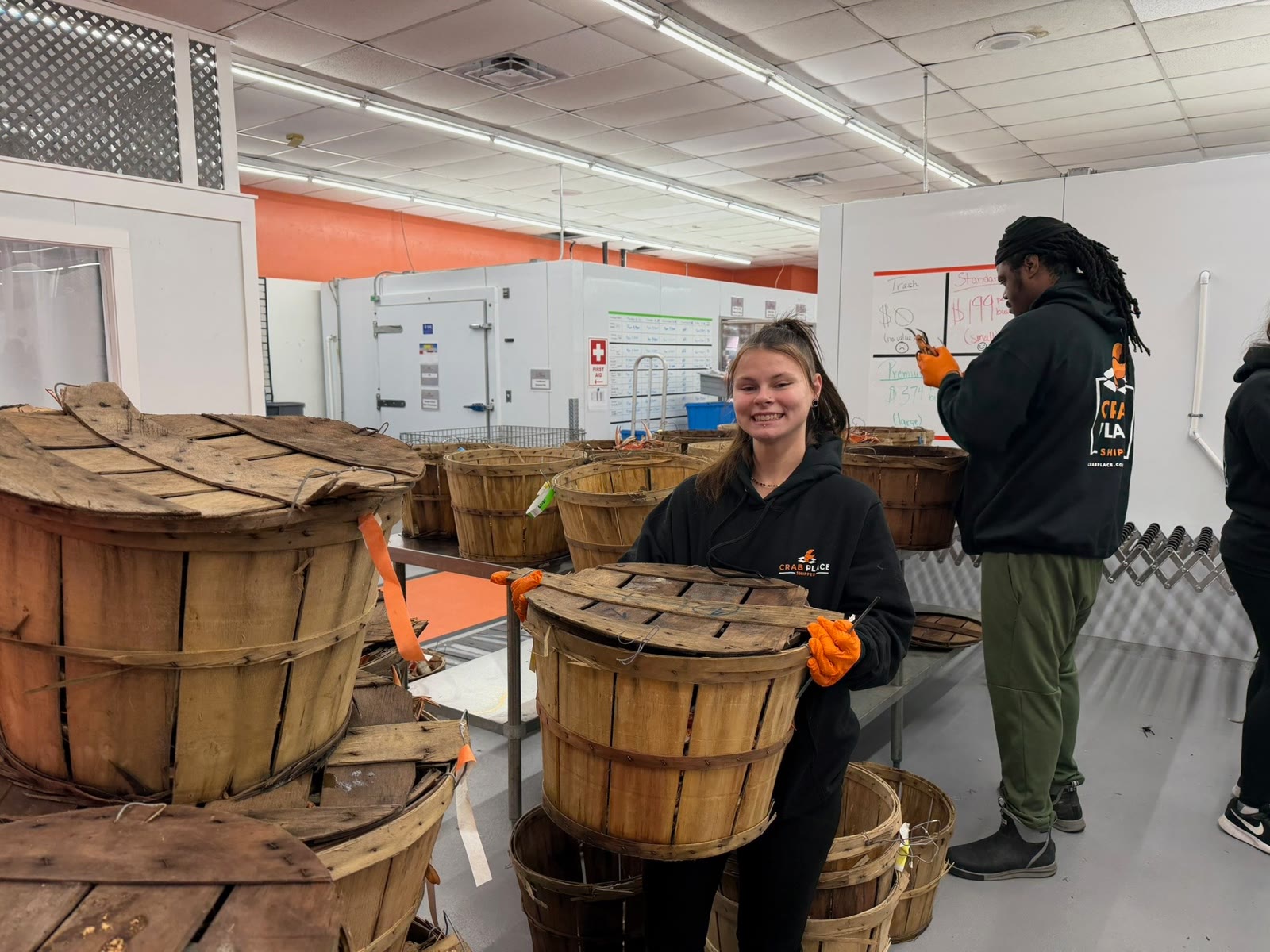 Crew members grading steamed crabs at the grade line, bushel baskets around them