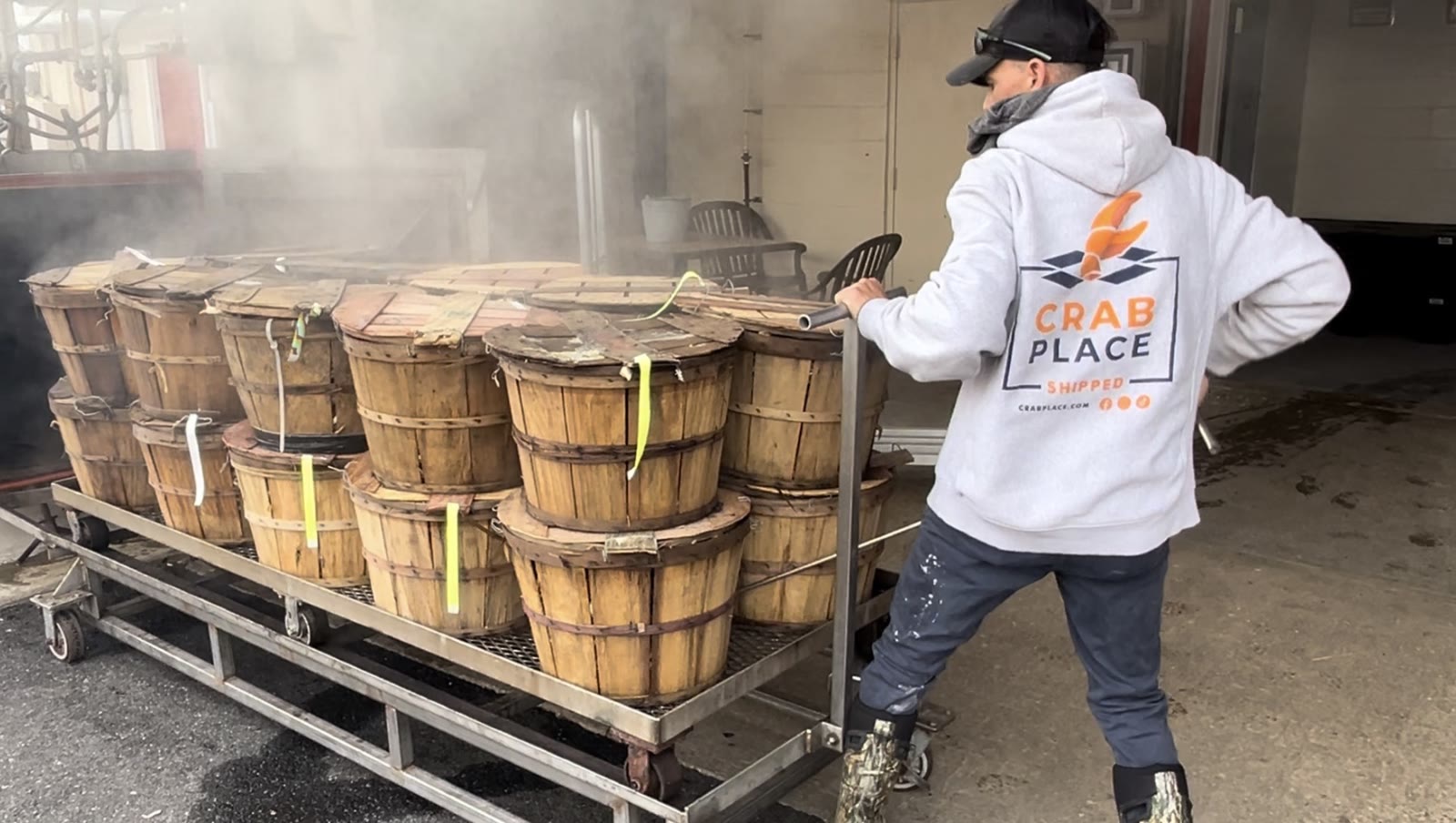 Bushels of crabs on a cart with steam rising, at the mouth of the retort