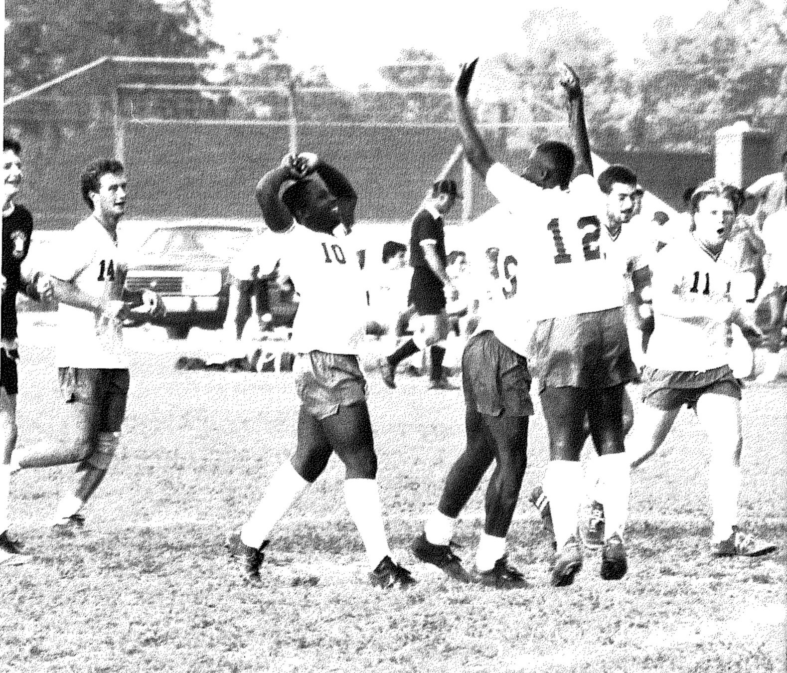 Yearbook photo of Crisfield High soccer players celebrating a goal with arms raised, with number 14 running in from the left.