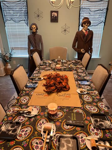 A dining table set for Halloween with crabs down the middle and two costumed figures behind it