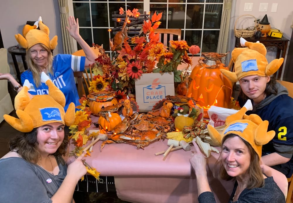 A family in turkey hats celebrating around a fall crab feast